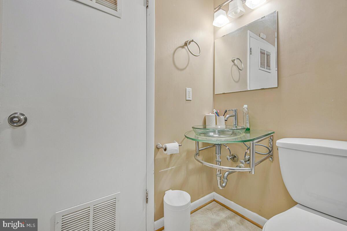 9695 Hitching Post Lane, Unit H Laurel, MD 20723 - Photo 11 of 19 a bathroom with a toilet a sink and mirror