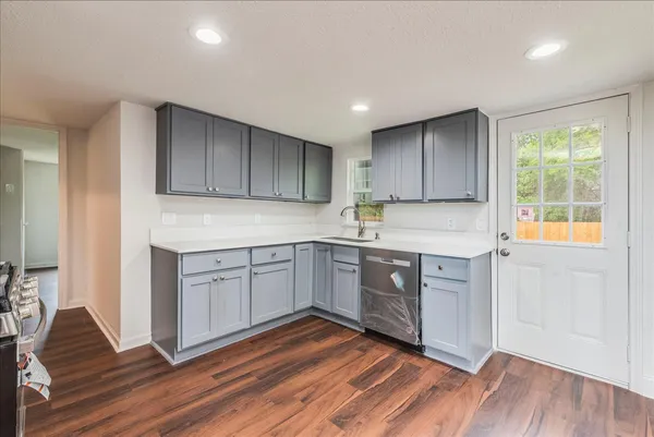 a kitchen with wooden floors and white cabinets
