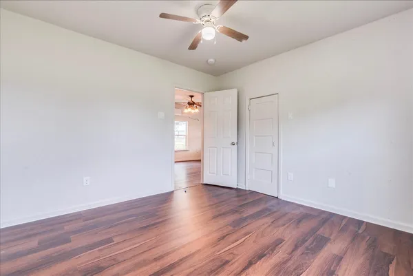 a view of an empty room with wooden floor