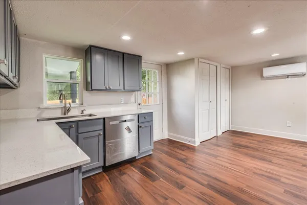 a kitchen with wooden floors and white cabinets