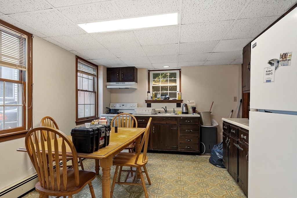 51 Crescent Street Wakefield, MA 01880 - Photo 15 of 20 a kitchen with stainless steel appliances granite countertop a stove a refrigerator a sink dishwasher a dining table and chairs with wooden floor