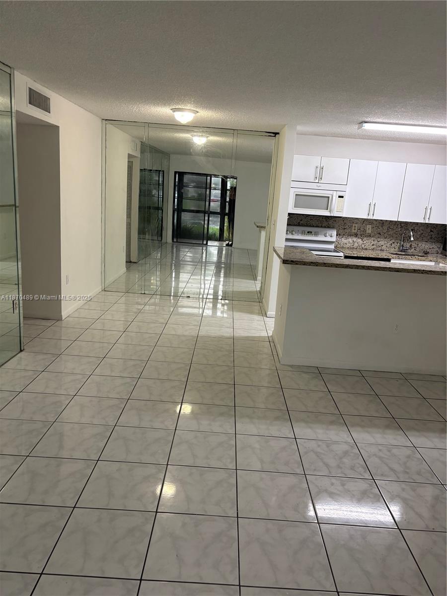 911 Northeast 199th Street, Unit 10414 Miami, FL 33179 - Photo 5 of 18 a kitchen with stainless steel appliances a sink and cabinets