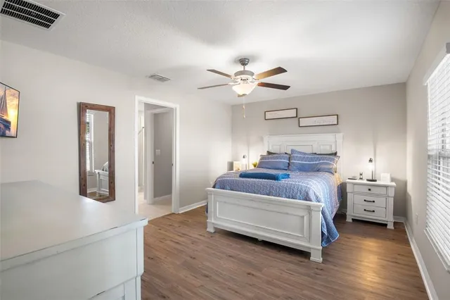 a spacious bedroom with a bed and a chandelier