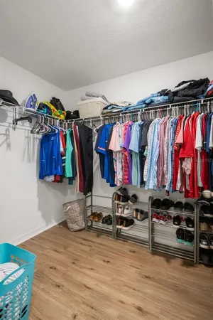 a view of walk in closet with clothes and shoes