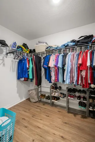 a view of walk in closet with clothes and shoes