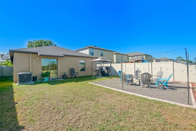 a view of a house with backyard and sitting area