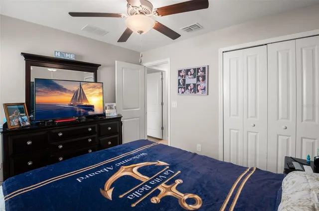 a bedroom with a bed and a flat tv screen on dresser
