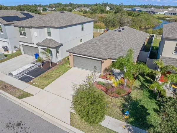 an aerial view of a house with swimming pool and mountains