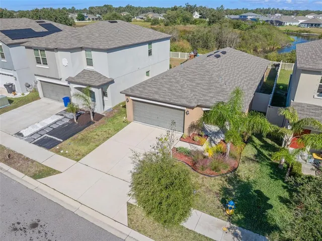 an aerial view of a house with swimming pool and mountains