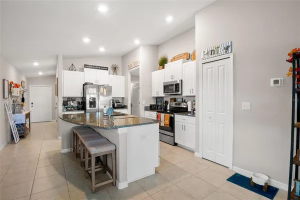 a kitchen with white cabinets and refrigerator