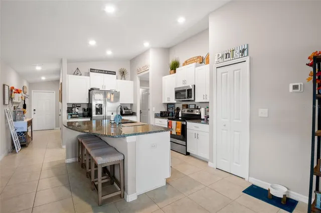 a kitchen with white cabinets and refrigerator