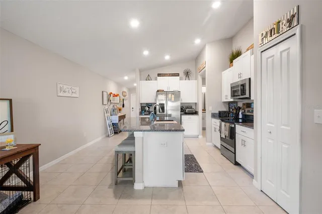 a kitchen with stainless steel appliances granite countertop a refrigerator and a sink