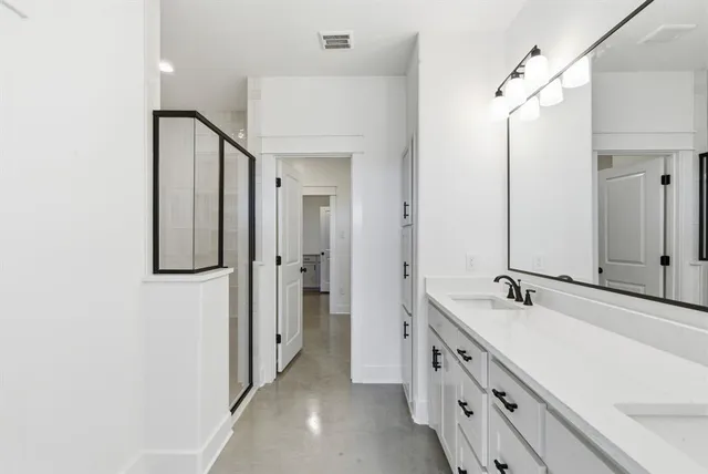 a spacious bathroom with a double vanity sink and a mirror