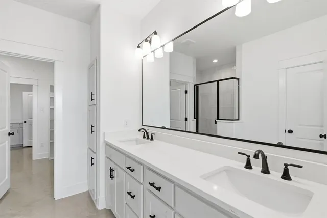 a bathroom with double vanity sinks and a mirror