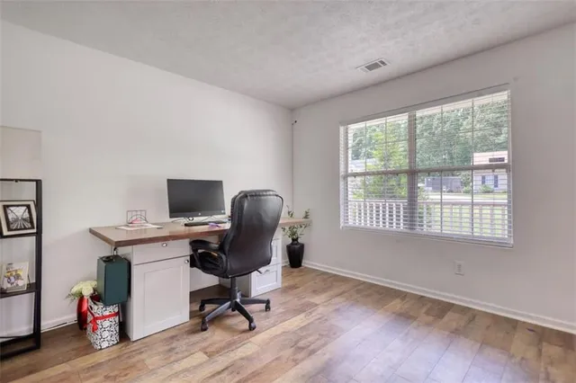 a kitchen with a sink dishwasher and white cabinets with wooden floor