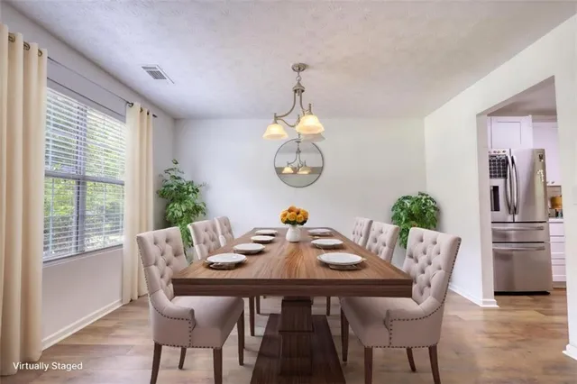 a kitchen with a table chairs refrigerator and cabinets