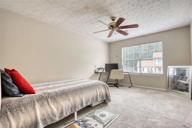 a view of a patio with table and chairs under an umbrella with a small yard