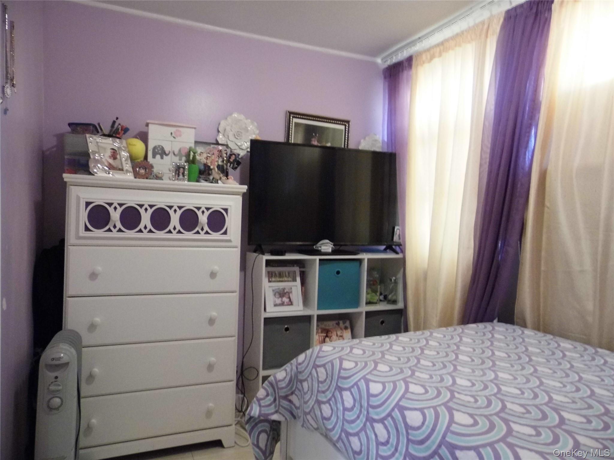 86-75 80th Street Queens, NY 11421 - Photo 12 of 20 a bedroom with a bed and a television