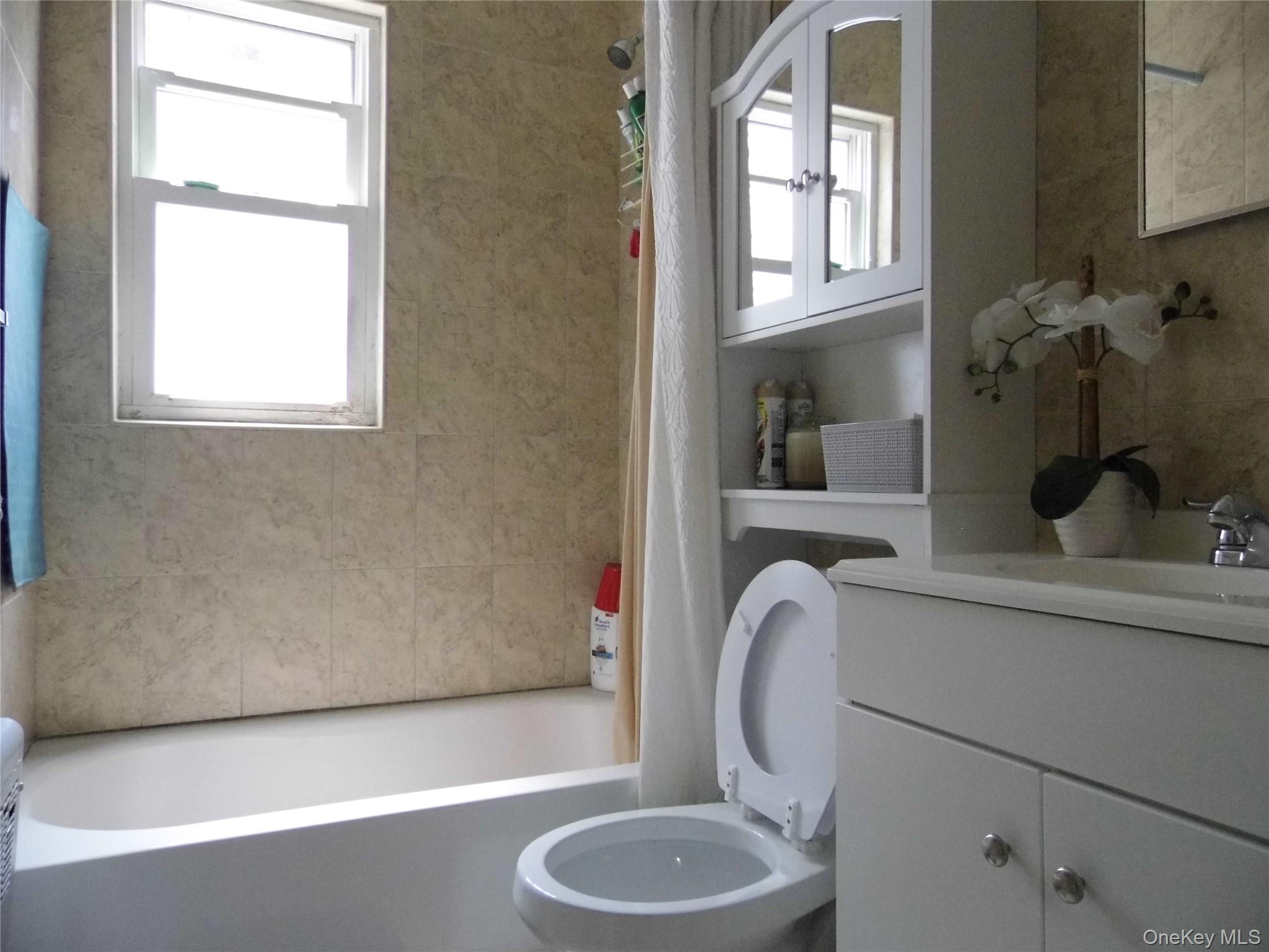 86-75 80th Street Queens, NY 11421 - Photo 13 of 20 a bathroom with a toilet and a sink