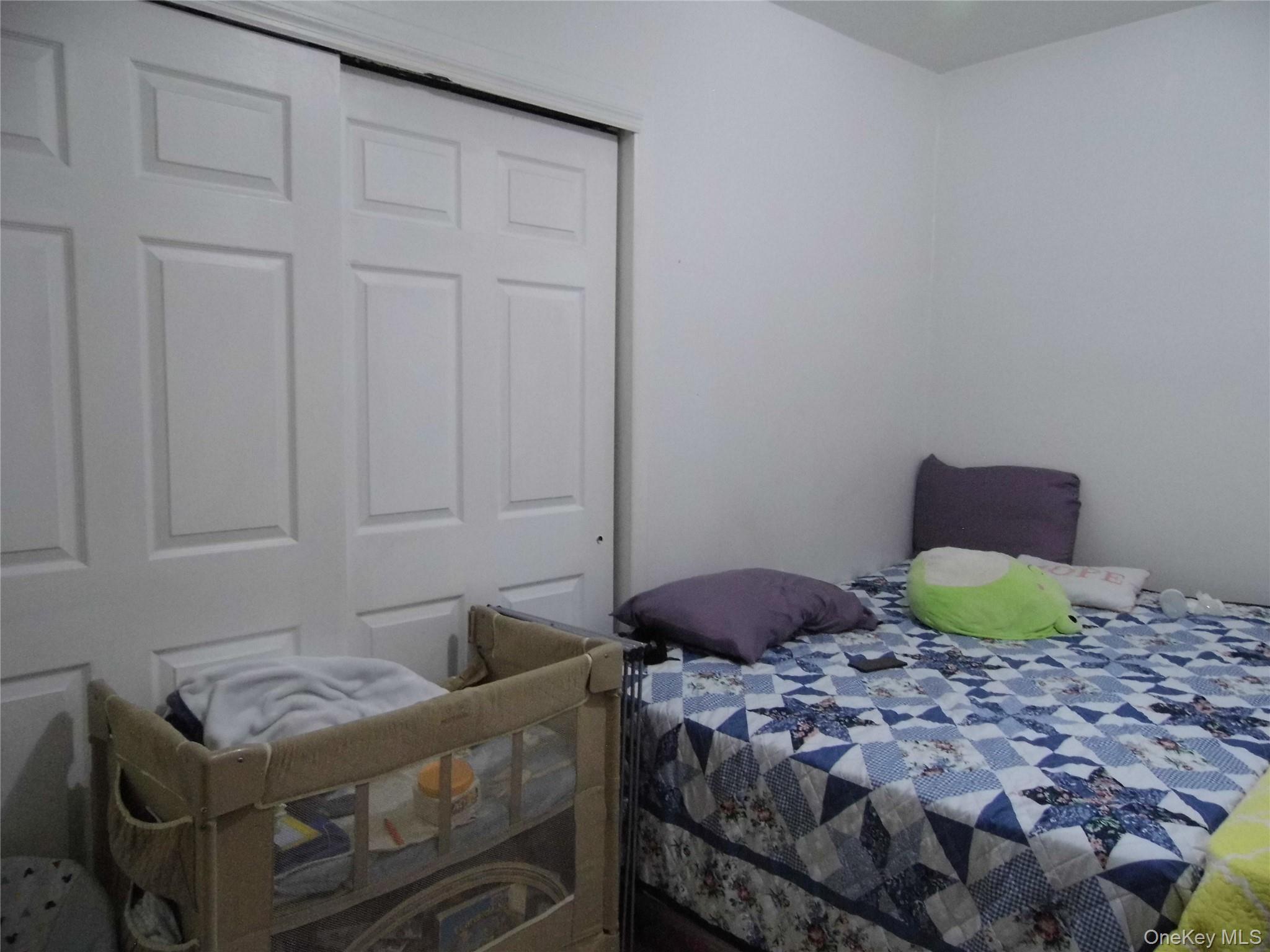 86-75 80th Street Queens, NY 11421 - Photo 15 of 20 a bedroom with a bed and a window