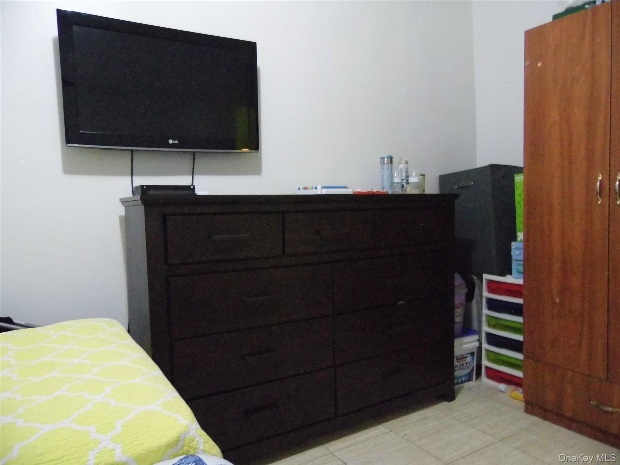 86-75 80th Street Queens, NY 11421 - Photo 16 of 20 a room with wooden floor and flat screen tv