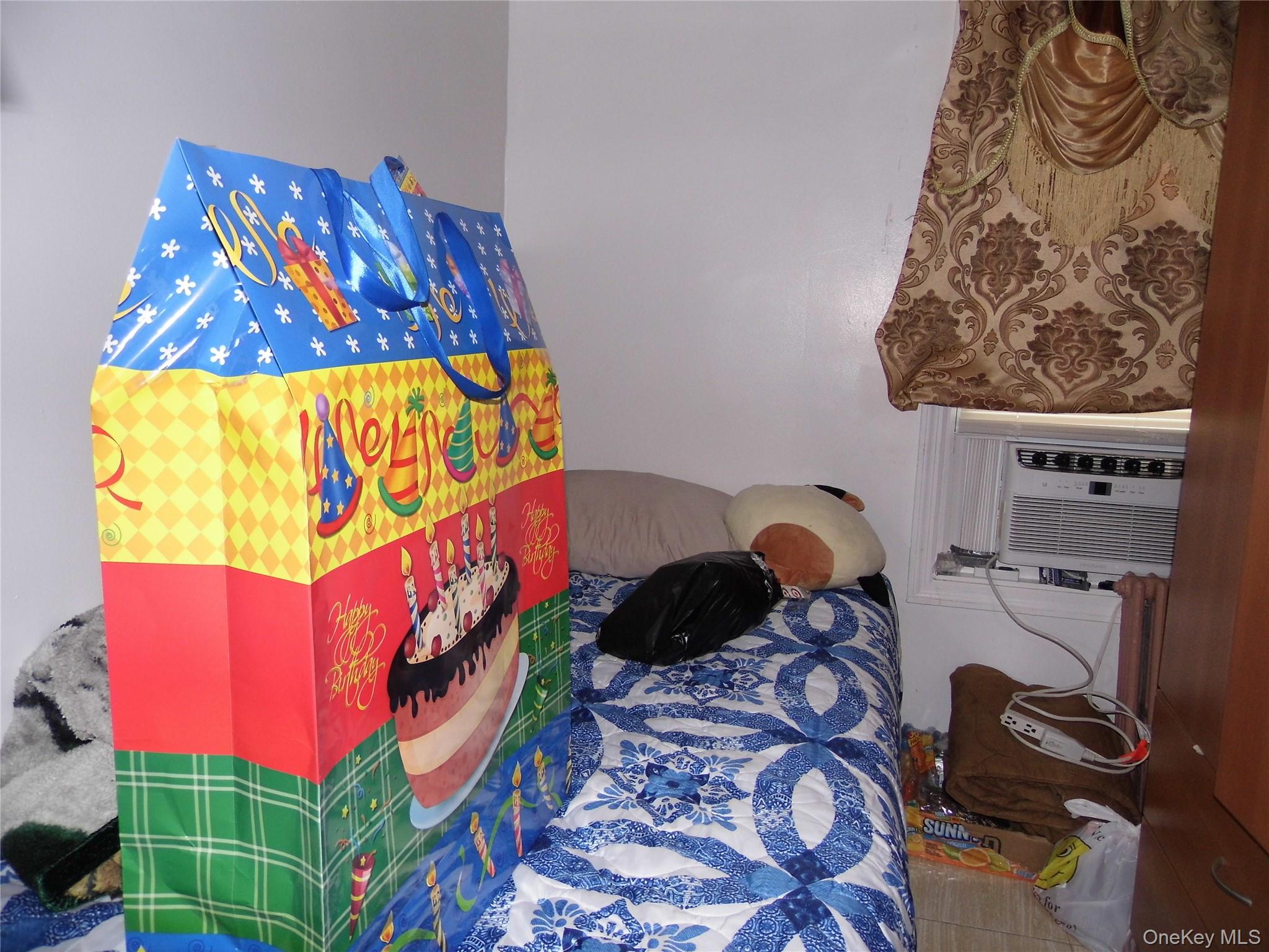 86-75 80th Street Queens, NY 11421 - Photo 18 of 20 a room that has a bed and a painting on the wall