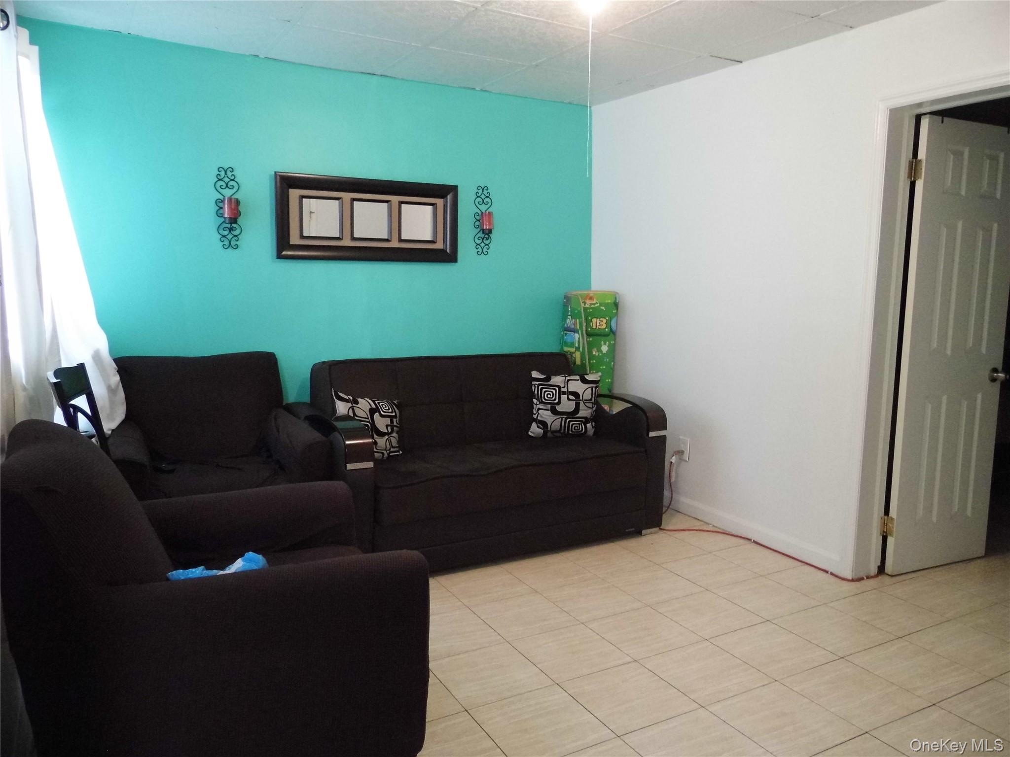 86-75 80th Street Queens, NY 11421 - Photo 5 of 20 a living room with furniture and a window