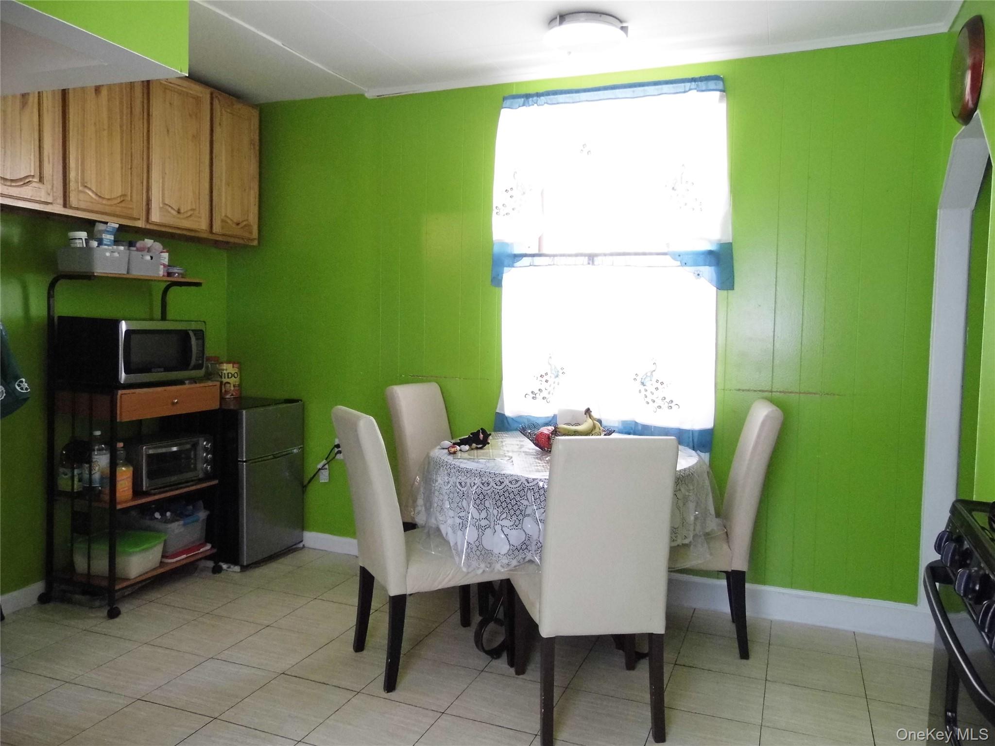 86-75 80th Street Queens, NY 11421 - Photo 7 of 20 a dining room with furniture and a window
