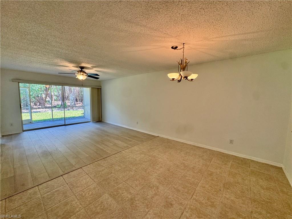 661 Squire Circle, Unit 101 Naples, FL 34104 - Photo 6 of 25 an empty room with windows and ceiling fan