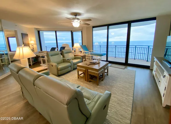 a living room with furniture and a floor to ceiling window
