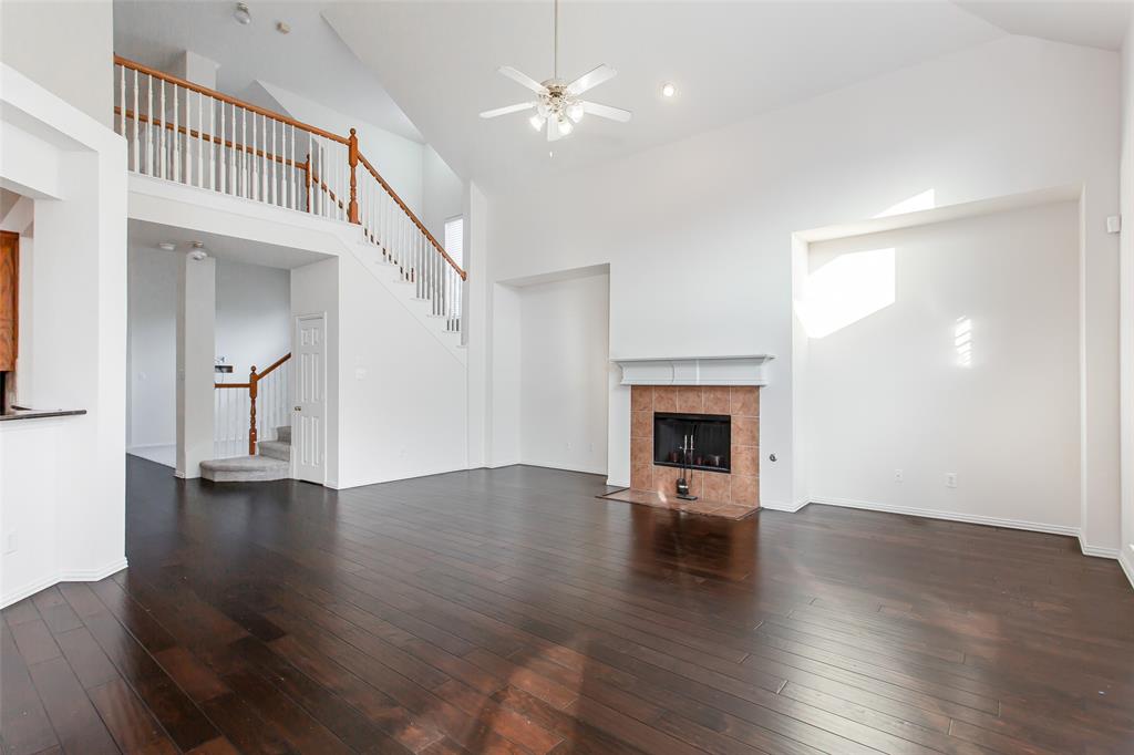 915 Falcon Trail Murphy, TX 75094 - Photo 20 of 40 an empty room with wooden floor fireplace and windows