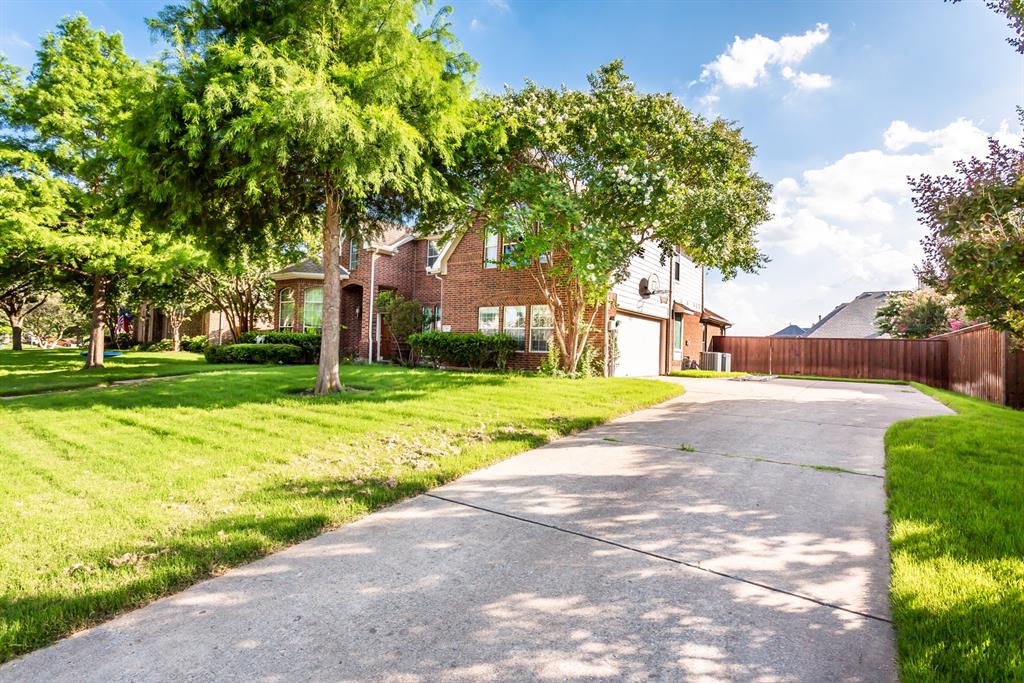 915 Falcon Trail Murphy, TX 75094 - Photo 2 of 40 a view of a yard with plants and large trees