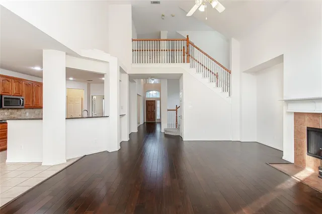 a view of a hallway with wooden floor and a kitchen