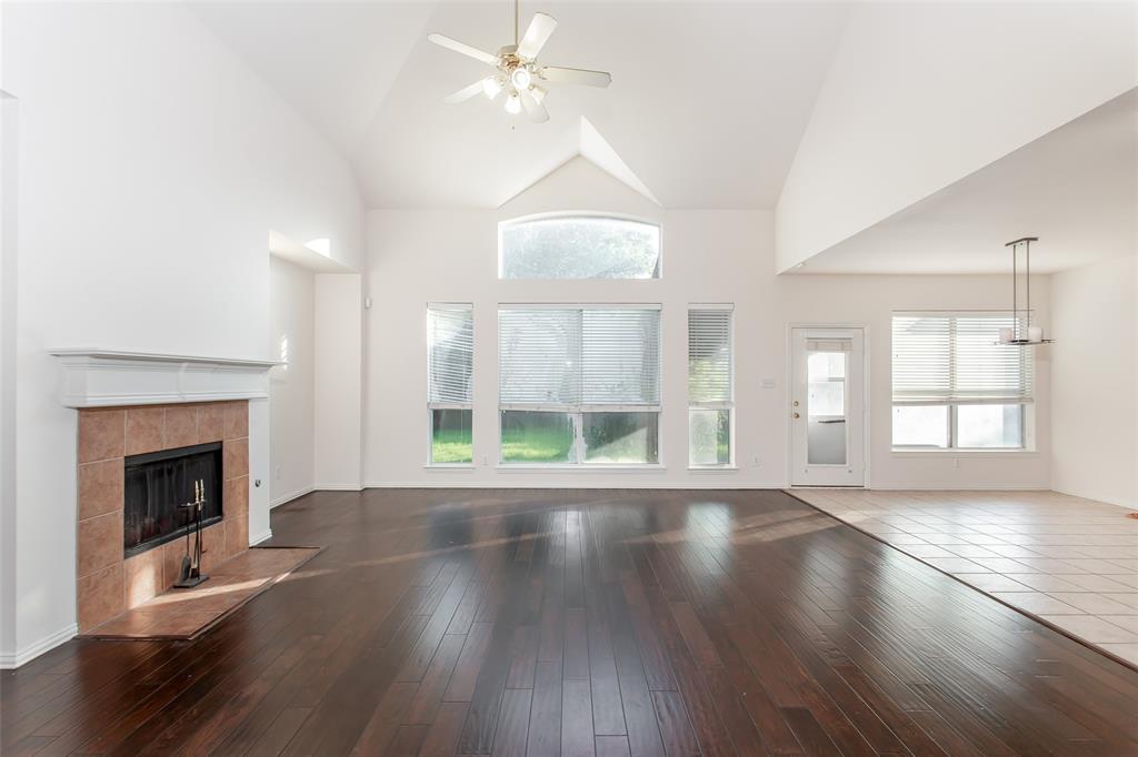 915 Falcon Trail Murphy, TX 75094 - Photo 9 of 22 an empty room with wooden floor fireplace and windows