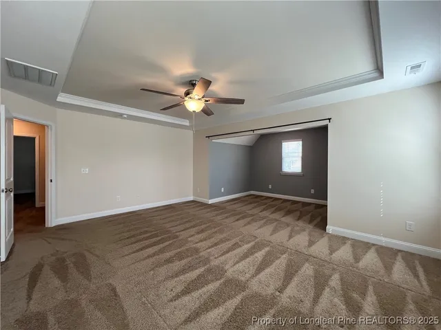a view of empty room with window and ceiling fan