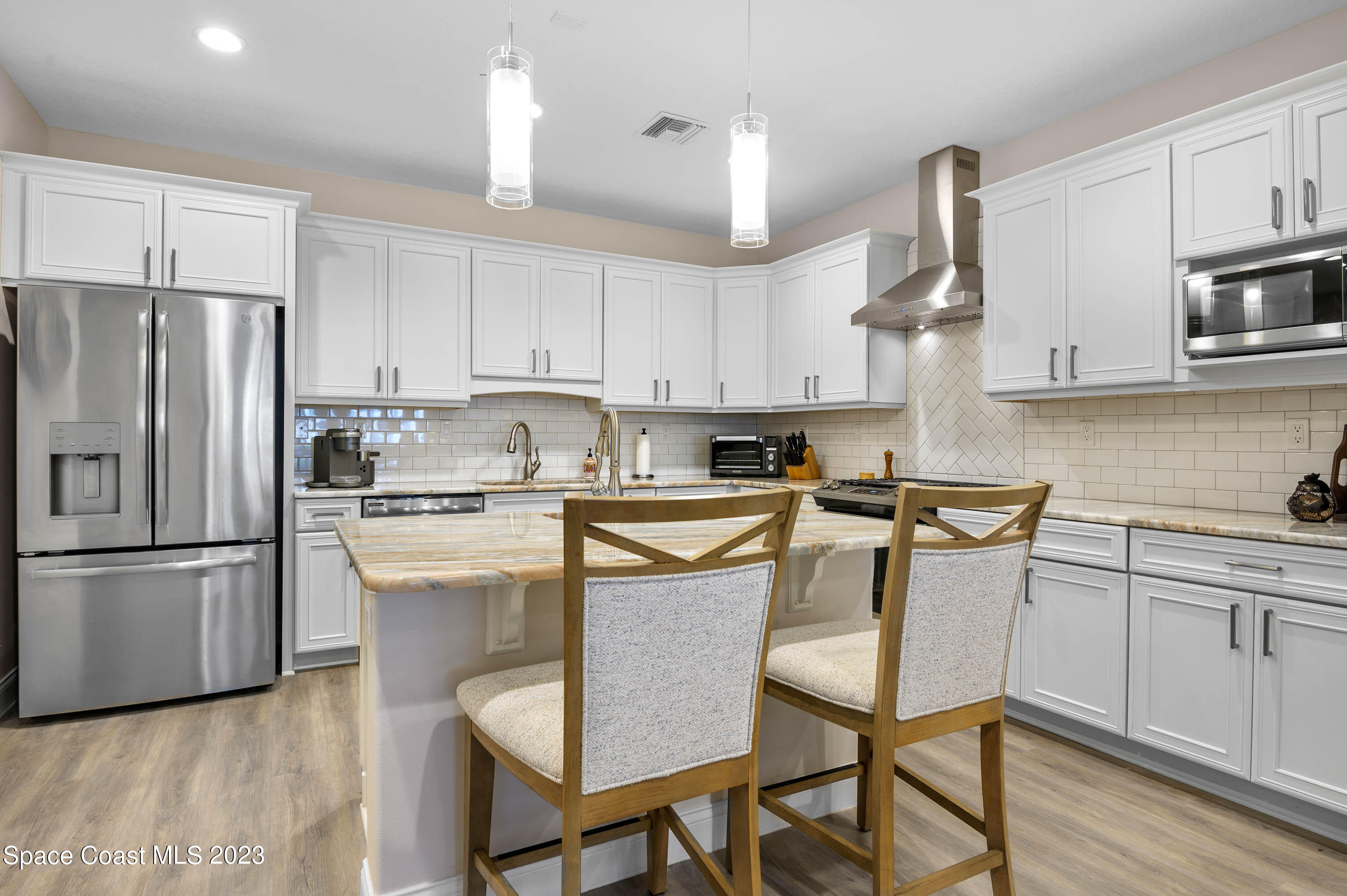 2240 Enjoya Lane Melbourne, FL 32901 - Photo 7 of 31 a kitchen with stainless steel appliances granite countertop a refrigerator a stove a sink dishwasher and a refrigerator with wooden floor