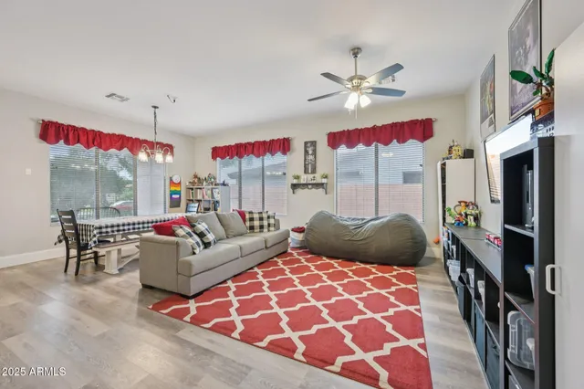 a living room with furniture kitchen and a flat screen tv