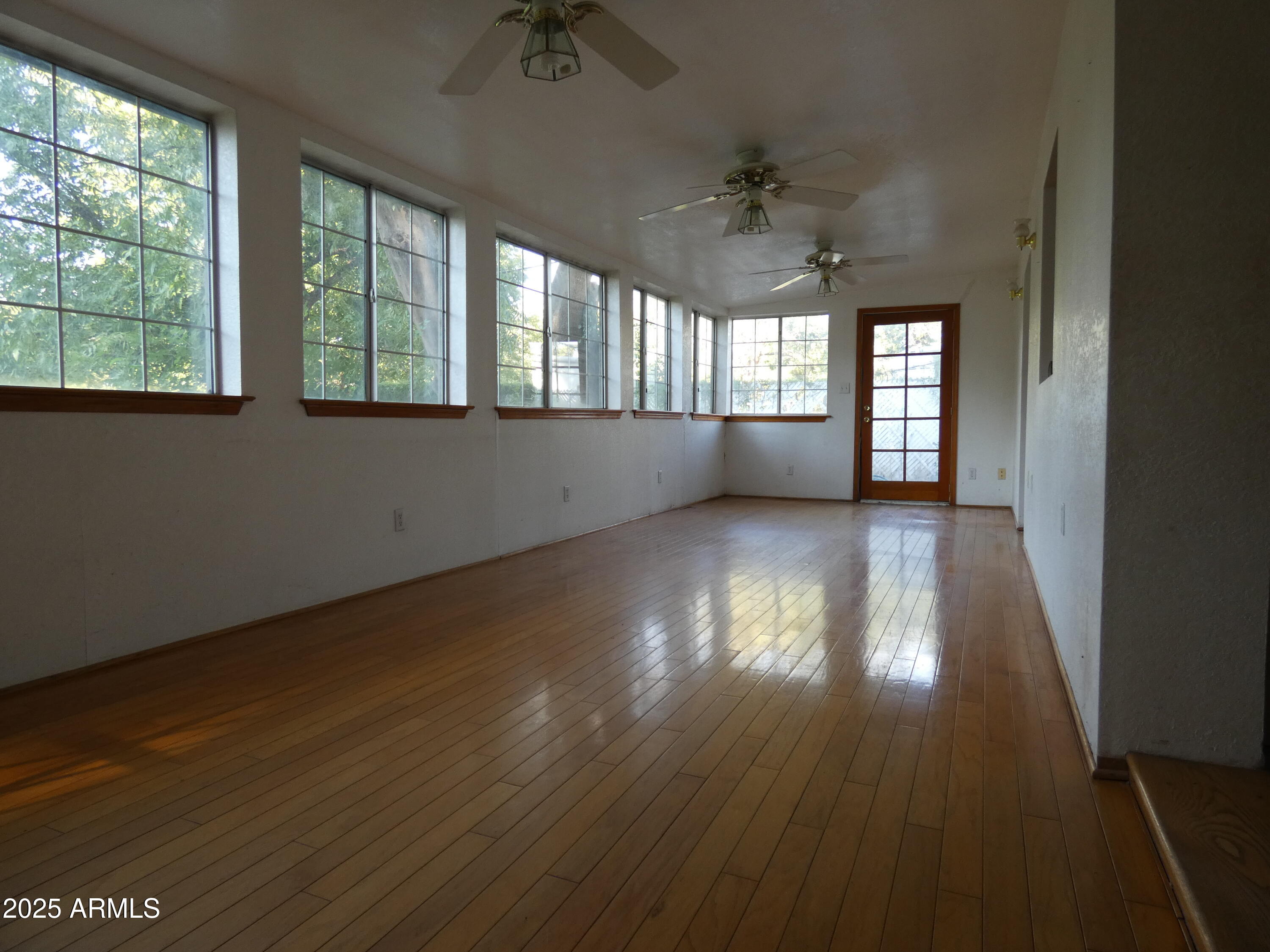 3214 West State Avenue Phoenix, AZ 85051 - Photo 9 of 35 an empty room with wooden floor and windows
