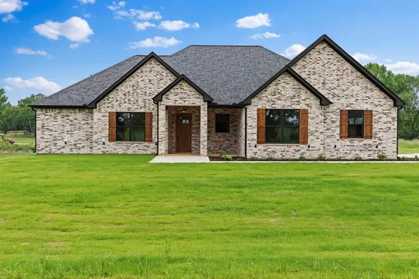 a front view of house with yard and green space