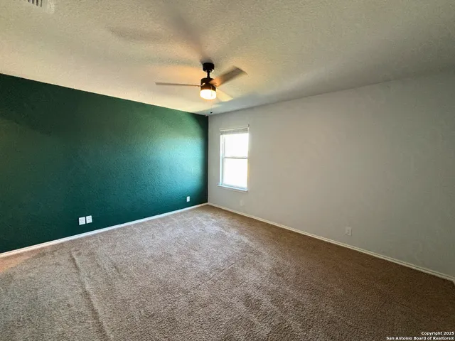 an empty room with a window and a ceiling fan