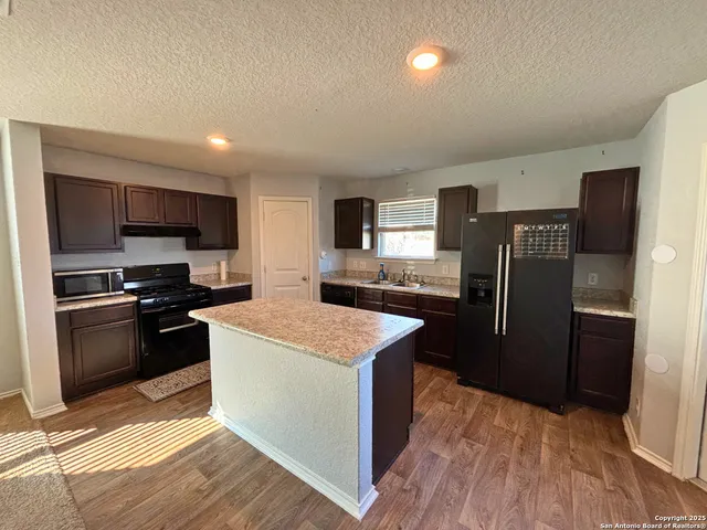 a kitchen with stainless steel appliances granite countertop a refrigerator stove and sink