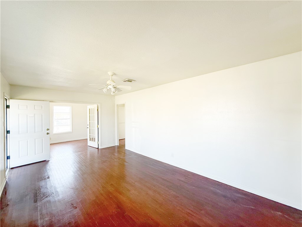 2325 1st Street Ingleside, TX 78362 - Photo 11 of 31 an empty room with wooden floor and windows