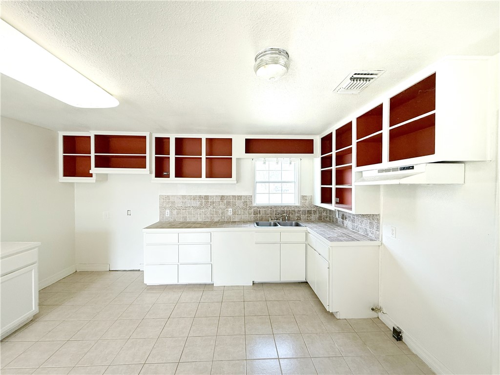2325 1st Street Ingleside, TX 78362 - Photo 14 of 31 a kitchen with a sink and cabinets