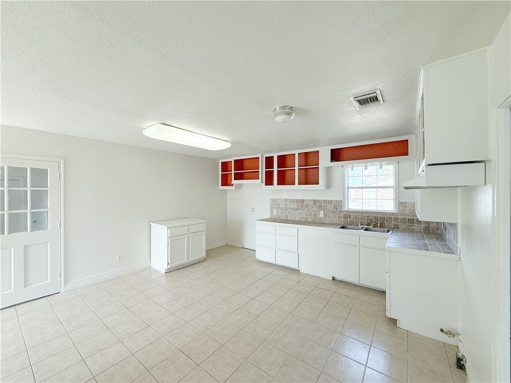 2325 1st Street Ingleside, TX 78362 - Photo 20 of 31 a kitchen with granite countertop white cabinets and white appliances