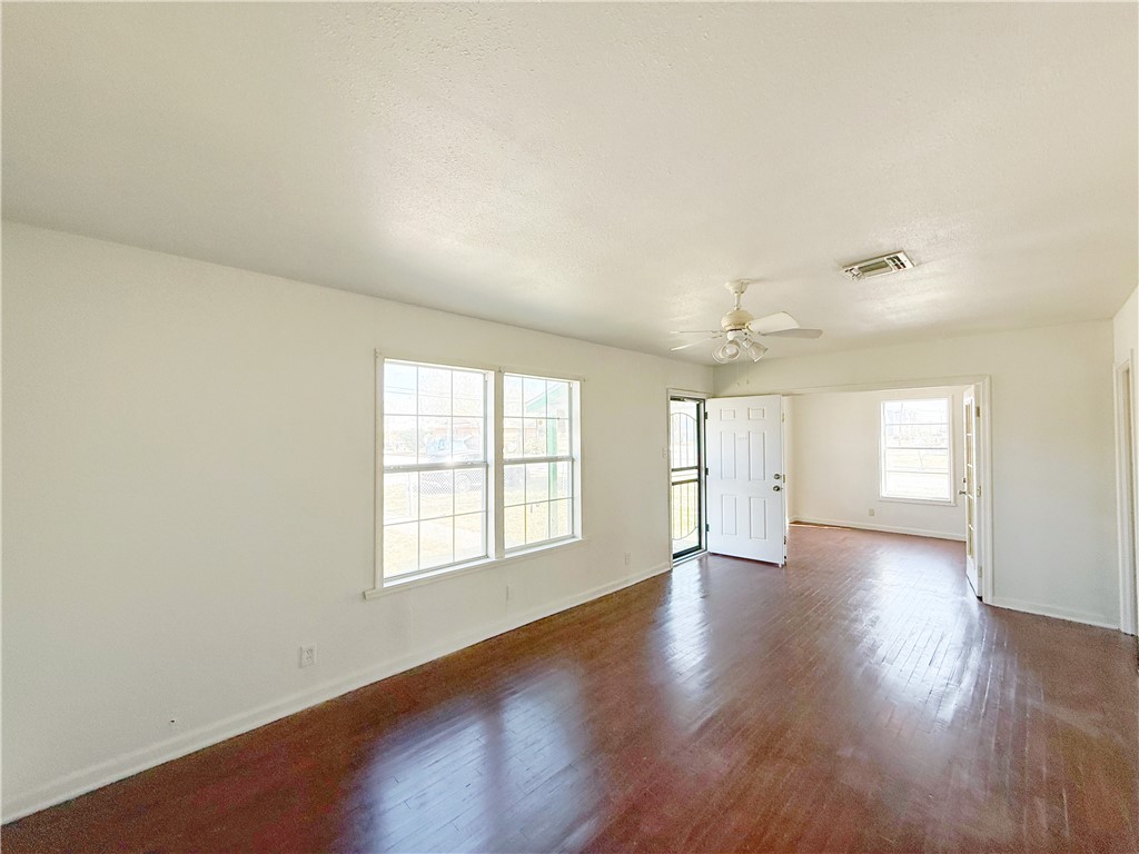 2325 1st Street Ingleside, TX 78362 - Photo 6 of 31 an empty room with wooden floor and windows