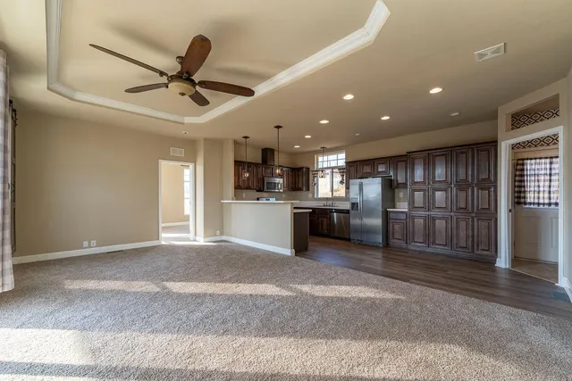 a kitchen with stainless steel appliances granite countertop a stove a sink dishwasher a refrigerator and a oven with wooden floor