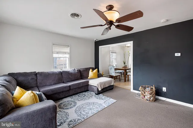 a living room with furniture and a ceiling fan