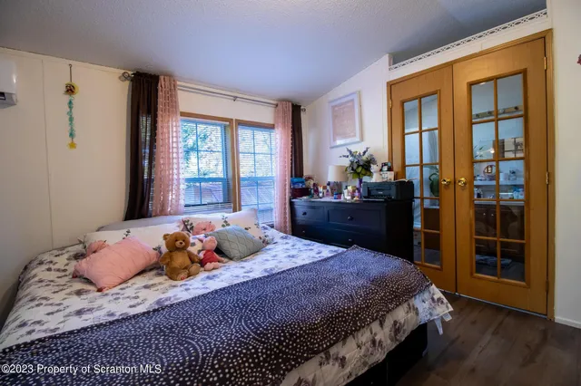 a bedroom with a bed and wooden floor
