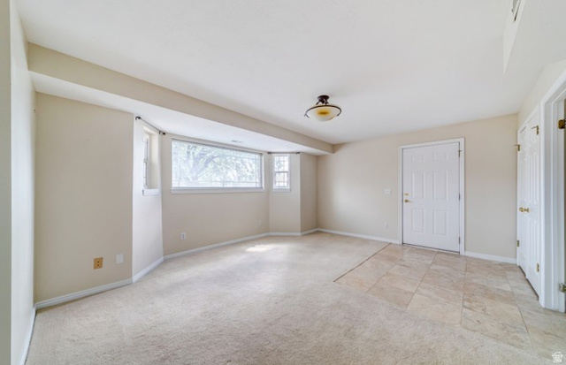 1273 Grayson Court Sandy, UT 84094 - Photo 23 of 27 Carpeted living space featuring recessed windows, neutral wall tones, a ceiling-mounted light fixture, and a tiled entry area