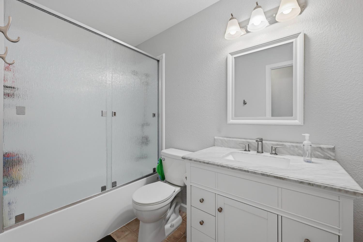 5013 Charter Road Rocklin, CA 95765 - Photo 22 of 35 a bathroom with a granite countertop sink a toilet and a mirror